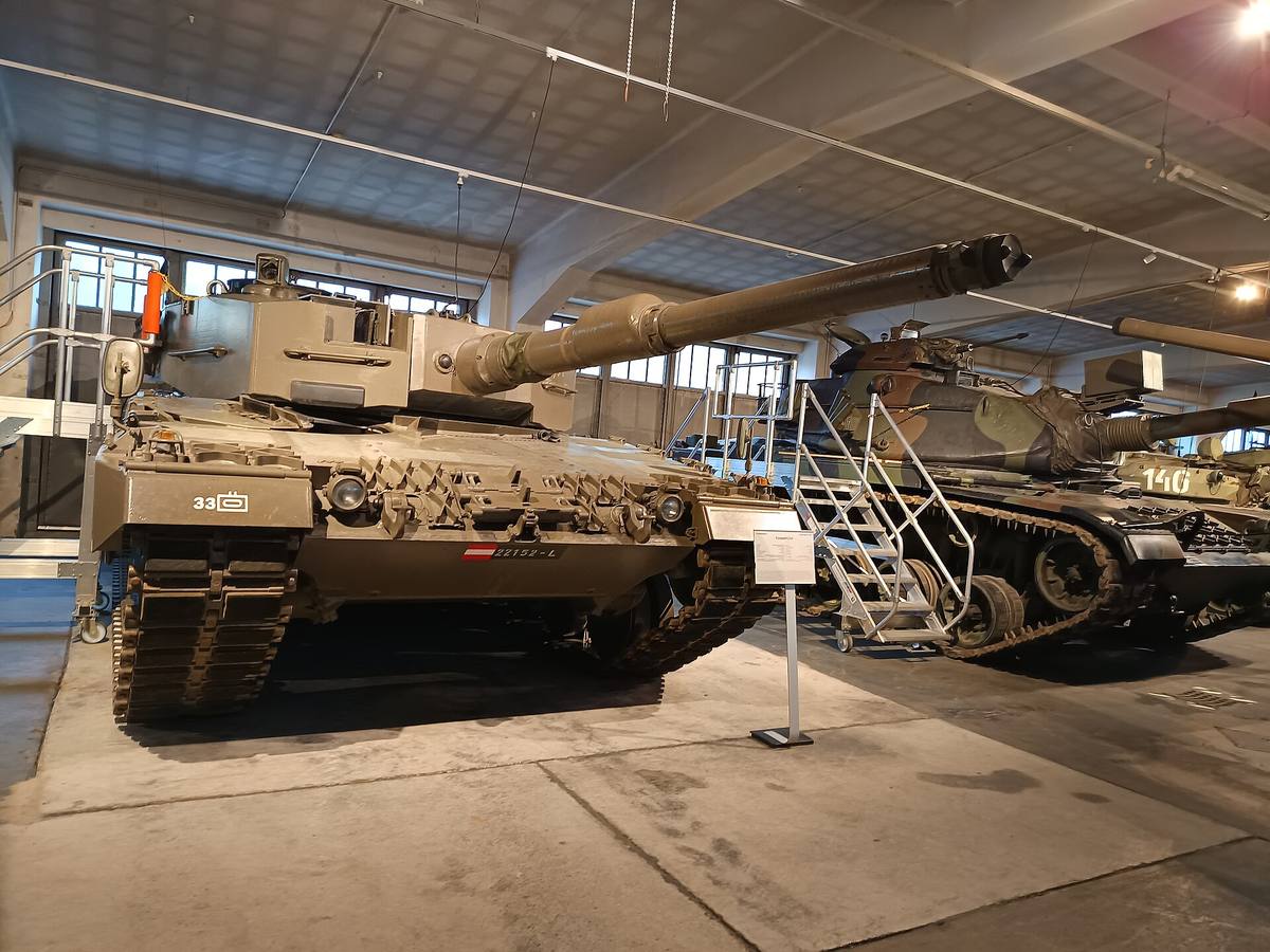 Tank Leopard 2A4 v hale vojenského muzea, za ním další pásová vozidla.