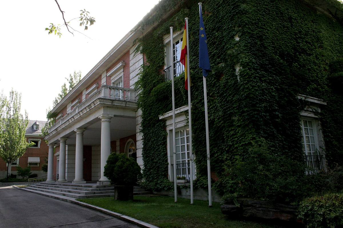 Nízká bílá budova pavilonu Rady ministrů v areálu La Moncloa se zeleným trávníkem před ní