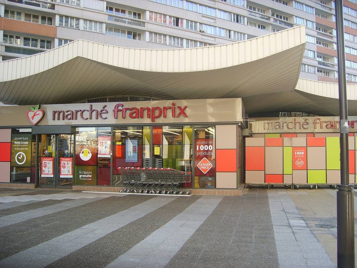 Prodejna řetězce Franprix pod betonovou stříškou na sídlišti, před vchodem nákupní vozíky, bez lidí