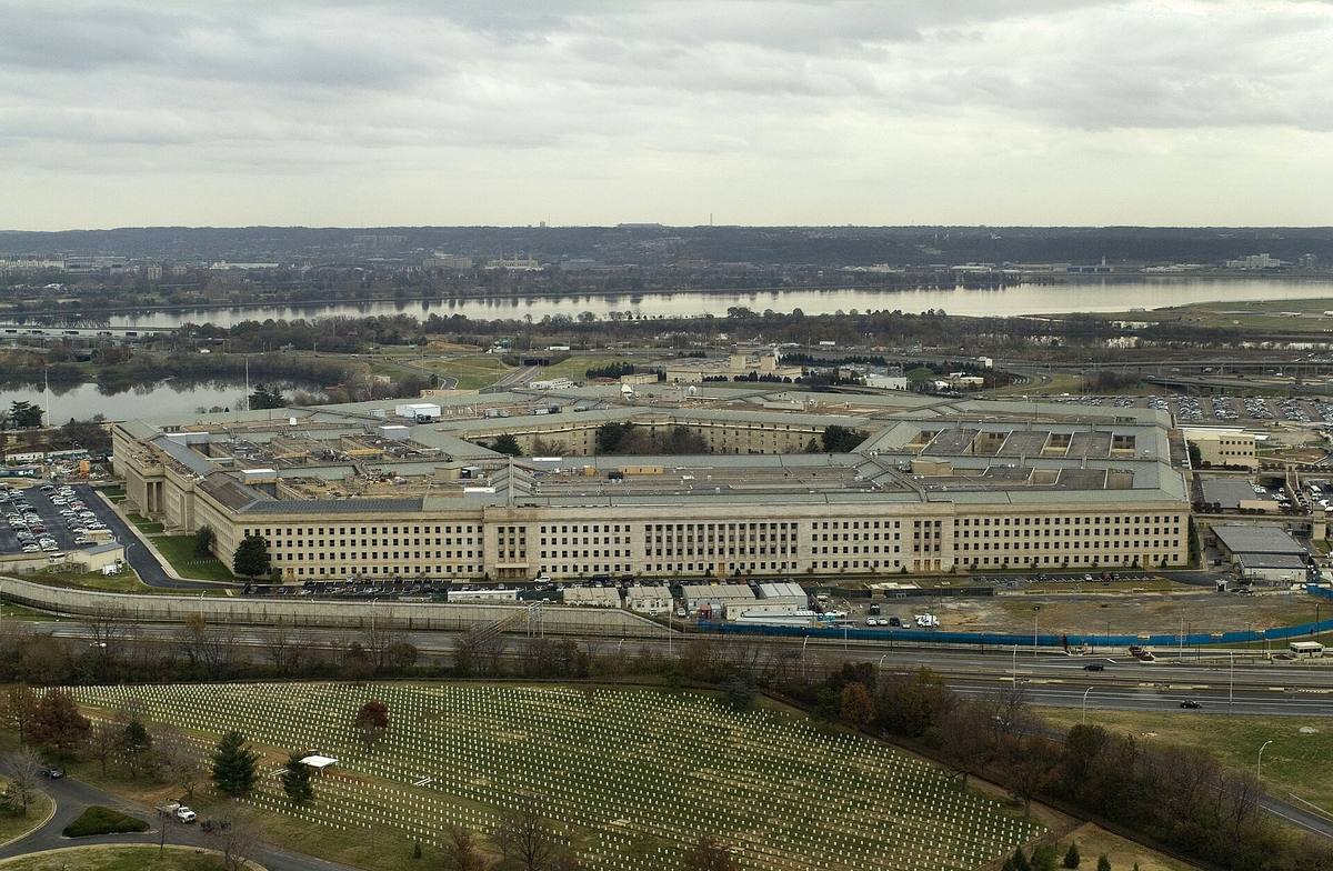 Letecký pohled na pětiúhelníkovou budovu Pentagonu mezi řekou Potomac a Arlingtonským hřbitovem.