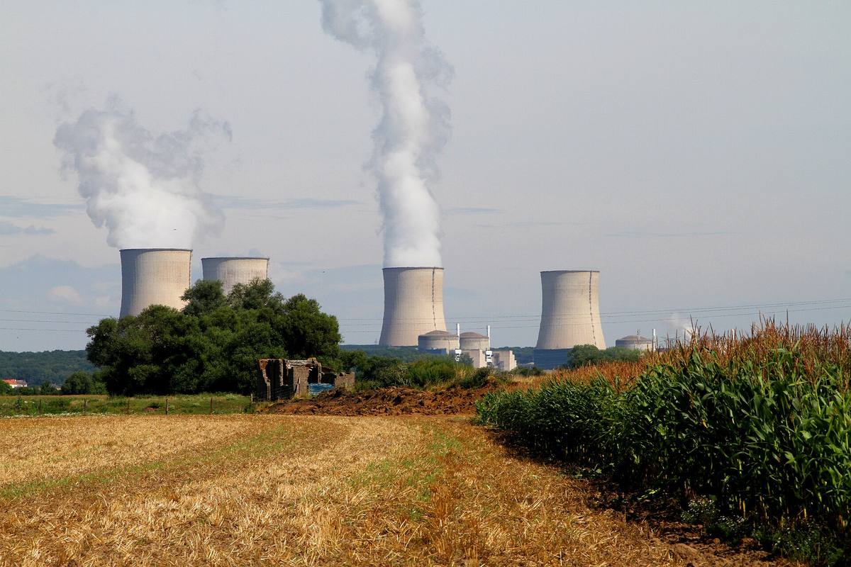 Čtyři chladicí věže jaderné elektrárny Cattenom za strništěm a kukuřičným polem