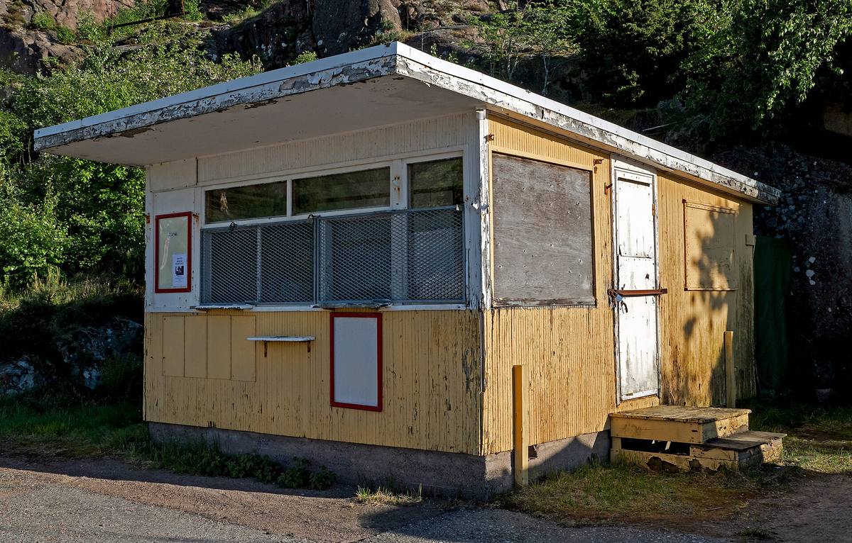 Zavřený dřevěný kiosek s okenicemi u přístavní hráze